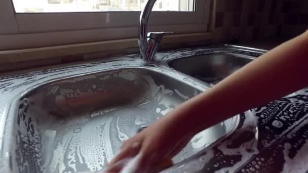Uma menina lava uma pia com espuma . — Vídeo de Stock