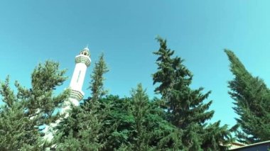 Ağaçların arasından Minare güzel görünümü.