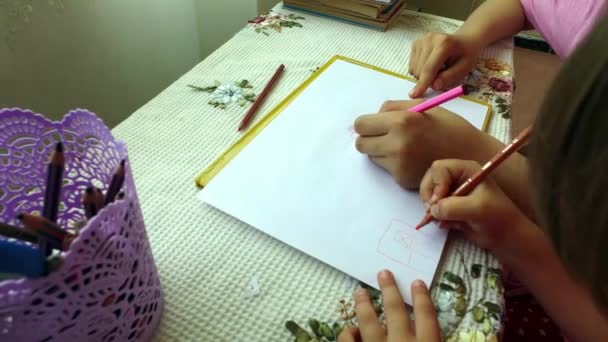 The girls draw with colored pencils sitting at the table. — Stock Video