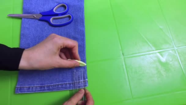 Делает отметины на джинсах и срезает ножницами — стоковое видео