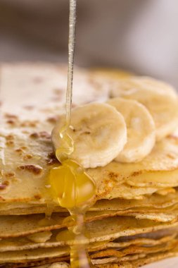 İnce krep muz ve bal ile. Maslenitsa. Hafif ahşap arka plan üzerinde Rus krep. Bir rustik tarzda.