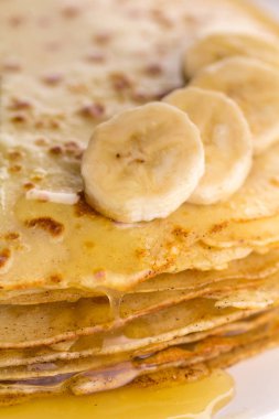 İnce krep muz ve bal ile. Maslenitsa. Hafif ahşap arka plan üzerinde Rus krep. Bir rustik tarzda.