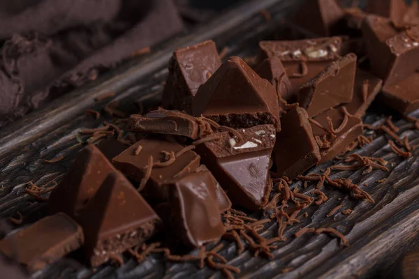 Chocolat au lait. Morceaux de chocolat au lait sur un fond en bois — Photo