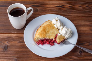 Taze ev yapımı pasta kiraz hamuru ve dondurma bir plaka üzerinde. Bir dilim kirazlı turta ahşap bir masa üzerinde kırmızı bir kabuk ile. Kirazlı turta ve lezzetli sıcak siyah kahve kupa.