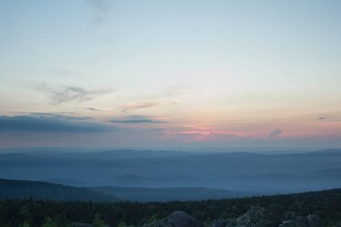Günbatımı dağlık arazi üzerinde. Güney Urallar doğası. Orman ve dağlar üzerinde gökyüzü günbatımı.