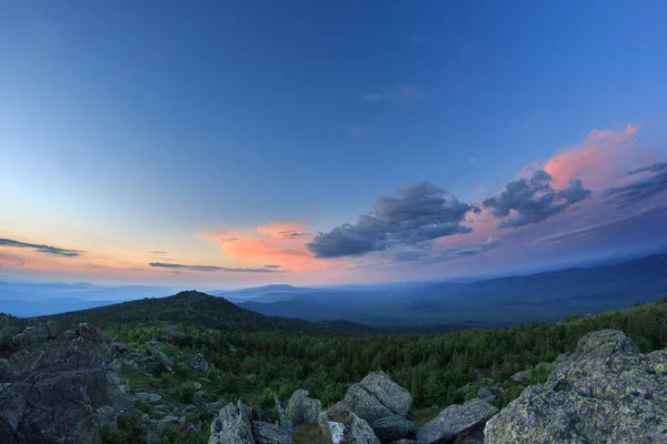 Sonnenuntergang über dem bergigen Gelände. die Natur des südlichen Ural. Abendhimmel über dem Wald und den Bergen. — Stockfoto