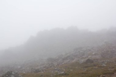 Kasvetli dağ manzarası. Sis dağlarda, kasvet dağlardan aşağı gelir. Dağ plaser siste.