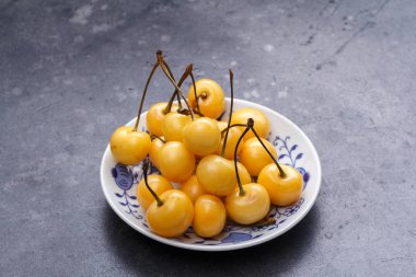 Bir daire karanlık bir arka plan üzerinde sarı kiraz.