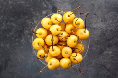 Karanlık bir arka plan üzerinde sarı kiraz.