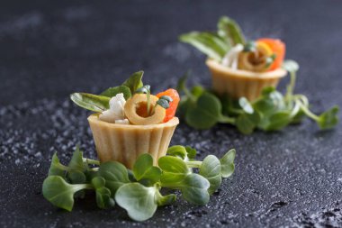 Tartlets mikro-yeşil koyu arka plan üzerinde somon ve peynir peynir ile.