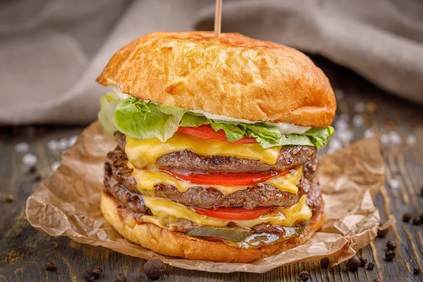 Üç biftek pirzola ve sebze ahşap arka plan üzerinde büyük hamburger.