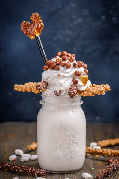 Unusual milkshake decorated with candies, marshmallows, whipped cream and other sweets. Milkshake for children. — Stock Photo, Image