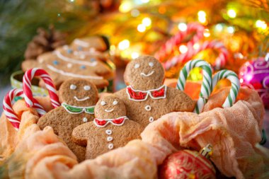 Çerezler küçük insanlar ve parlayan çelenk arka plan üzerinde Noel ağaçları şeklinde. Yeni yıl kutlama aile