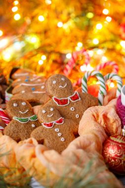 Afiş sitenin Noel için. Zencefilli bisküvi parlak renkli çelenk arkasındaki küçük adamlar şeklinde. Noel davranır ve dekorasyon.