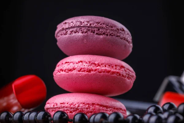 Macarrones de tonos rosados con un tubo de barniz para una manicura ideal y un hilo de cuentas . — Foto de Stock