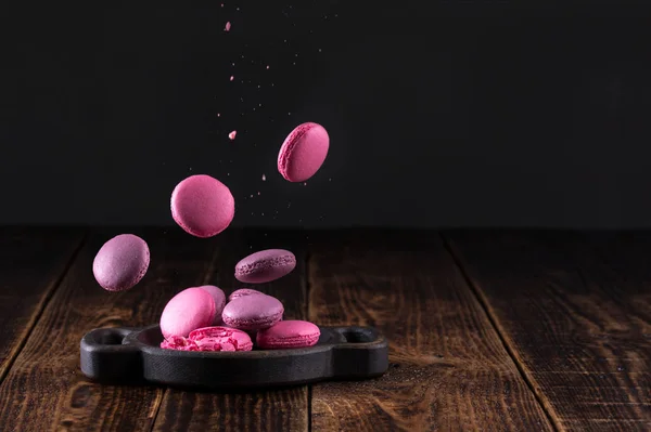 Delicate levitating macaroons on a wooden background. — Stock Photo, Image