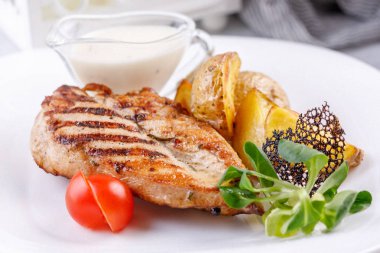 İştah açıcı ızgara tavuk fileto patates dilimleri ile.