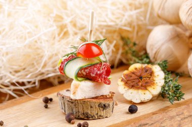 Salam ve ahşap bir kesim üzerinde taze sebze ile kanepe. Rustik.