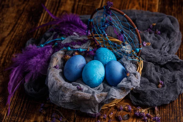 Una canasta de mimbre con huevos de Pascua pintados de azul . — Foto de Stock