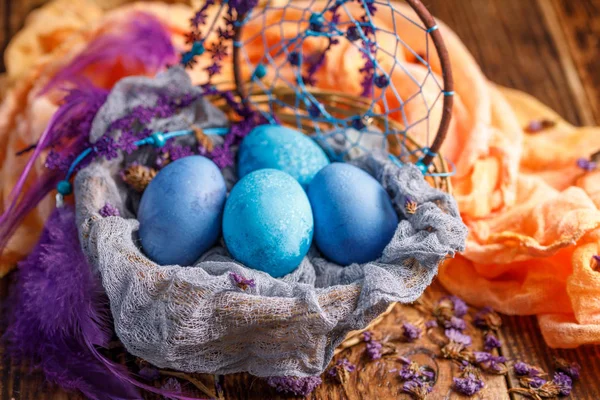 Los huevos de Pascua en una canasta de mimbre están pintados en un inusual color azul . — Foto de Stock