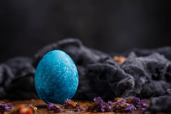 Un huevo, originalmente pintado de azul. Bodegón sobre fondo de madera . — Foto de Stock