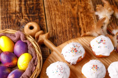 Olağandışı boyalı Paskalya yumurtaları ve gemide, tarzı ve ince tüyleri beyaz sır kekler.