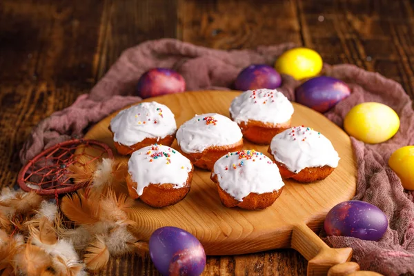 Cupcakes på en dekorativ styrelse och ovanligt målade påskägg. — Stockfoto