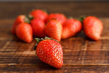 Olgun çilek ahşap tablo üzerinde arka plan bulanık. Taze meyveleri lezzetli. Makro.