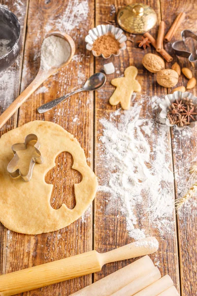Klasik zencefilli bisküvi küçük adamlar şeklinde yapma süreci. Natürmort malzemeler ve figurines ahşap bir zemin üzerine. — Stok fotoğraf