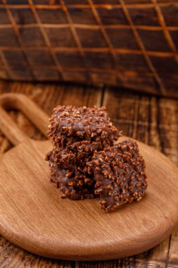 Çikolatalı kurabiye düşük ışıkta ahşap bir tahta üzerinde üst üste. Yakın çekim.