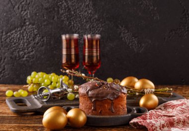 Bir güzel Paskalya natürmort metninizin altında bir yer ile. Lezzetli ev yapımı Paskalya pastada çikolata sır, vintage gözlük ile kırmızı şarap ve geleneksel yumurta boyalı..