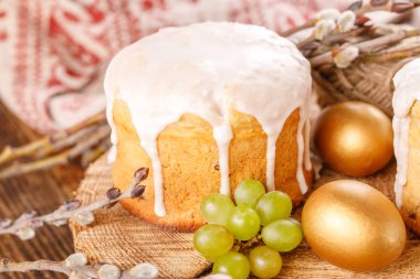 Paskalya kek ve renkli yumurta şenlikli Paskalya masada. Altın yumurta ve ahşap arka plan üzerinde geleneksel Paskalya kek.