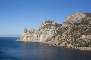 Sakin bir günde deniz ve dağ manzarası.