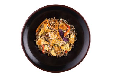 İzole üzerinde beyaz arka plan buğday noodle sebzeli ve mantar ile teriyaki sos. Siyah bir tabak içinde buğday noodle.
