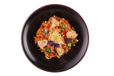 İzole üzerinde beyaz arka plan buğday noodle ile et ve sebze altında teriyaki sosu. Siyah bir tabak içinde buğday noodle.