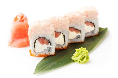 Ton balığı ve bir muz yaprağına ortaya konulan ihale Yengeç mousse ile orijinal suşi rulo. İzole. Beyaz bir arka plan üzerinde suşi roll.