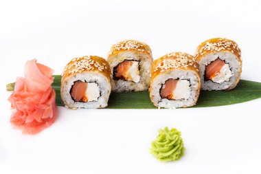 Zarif ve özgün suşi rulo somon füme ve peynir omlet içinde bir muz yaprağına ortaya koydu. İzole. Beyaz bir arka plan üzerinde suşi roll.