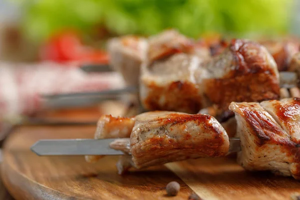 Domuz eti sulu Kebap bir açık ateş üzerinde pişmiş. Ahşap arka plan üzerinde iştah açıcı natürmort.