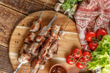 İştah açıcı şiş kebap domuz dan taze sebze ile ahşap bir gemide ortaya koydu. Natürmort ahşap arka plan üzerinde.