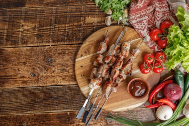 Şiş kebap ahşap bir gemide ortaya koydu. İştah açıcı et bir açık ateş üzerinde pişmiş. Et ve taze sebze ile natürmort.