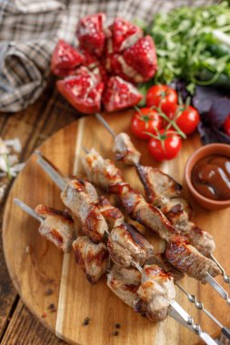Ahşap arka plan üzerinde domuz dan şiş kebap. İştah açıcı et bir açık ateş ve taze sebze pişmiş. Rustik.