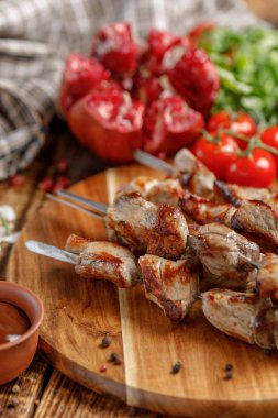 Pişmiş et şiş üzerinde bir ateş açın. Natürmort Tekstil ahşap zemin ile.