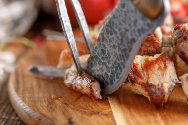 Özgün bir bıçak ve çatal ile kesmeye başlar açık bir yangın sulu et pişmiş.