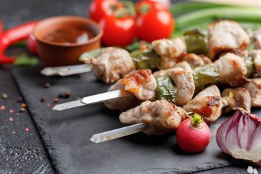 Siyah bir arka plan üzerinde domuz üzerinden hassas şiş kebap. Açık ateş ve Barbekü soslu taze sebze pişmiş et. Natürmort.