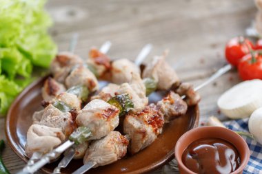 Açık bir yangın Barbekü soslu domuz eti üzerinden iştah açıcı şiş kebap pişirdim. Ahşap arka plan üzerinde natürmort. Yakın çekim.