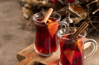 İki bardak noel şarabı portakallı ve baharatlı ve dokusal bir arka planda. Seçici odaklanma. Boşluğu kopyala.