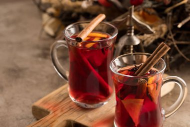 İki bardak noel şarabı portakallı ve baharatlı ve dokusal bir arka planda. Seçici odaklanma. Boşluğu kopyala.