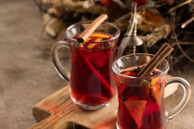 İki bardak noel şarabı portakallı ve baharatlı ve dokusal bir arka planda. Seçici odaklanma. Boşluğu kopyala.