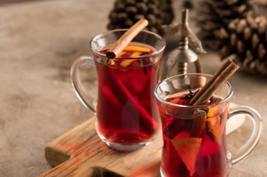 İki bardak noel şarabı portakallı ve baharatlı ve dokusal bir arka planda. Seçici odaklanma. Boşluğu kopyala.