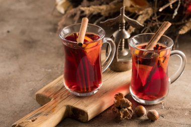İki bardak noel şarabı portakallı ve baharatlı ve dokusal bir arka planda. Seçici odaklanma. Boşluğu kopyala.